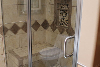Mid-sized transitional master beige tile and ceramic tile ceramic tile and beige floor alcove shower photo in Other with beige walls and a hinged shower door
