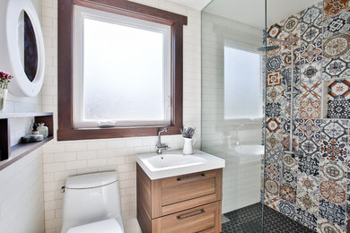 Ejemplo de cuarto de baño moderno con armarios estilo shaker, puertas de armario de madera clara, baldosas y/o azulejos multicolor, paredes blancas, aseo y ducha, ducha con puerta con bisagras y ducha a ras de suelo