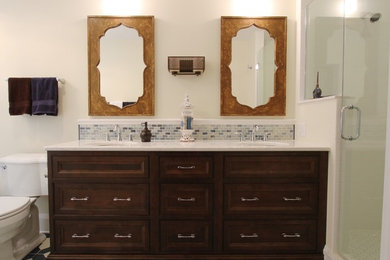 Inspiration for a large mediterranean ensuite bathroom in Milwaukee with freestanding cabinets, dark wood cabinets, a built-in bath, a two-piece toilet, white tiles, metro tiles, beige walls, cement flooring, a submerged sink, engineered stone worktops, a hinged door, an alcove shower and blue floors.