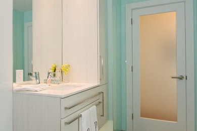 Imagen de cuarto de baño contemporáneo con lavabo bajoencimera, armarios con paneles lisos y puertas de armario de madera clara