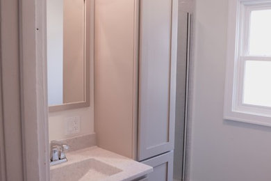 他の地域にある小さなトラディショナルスタイルのおしゃれなマスターバスルーム (フラットパネル扉のキャビネット、グレーのキャビネット、アルコーブ型シャワー、分離型トイレ、グレーのタイル、サブウェイタイル、グレーの壁、クッションフロア、一体型シンク、オニキスの洗面台、グレーの床、開き戸のシャワー、グレーの洗面カウンター) の写真