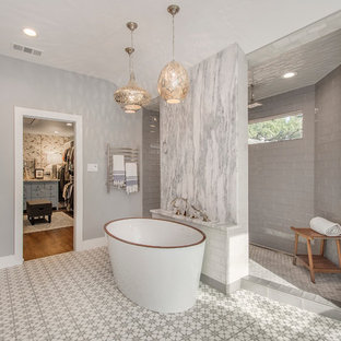 Foto de cuarto de baño principal, bohemio, grande, con armarios con paneles lisos, puertas de armario de madera clara, bañera exenta, ducha abierta, sanitario de dos piezas, baldosas y/o azulejos grises, baldosas y/o azulejos de cemento, paredes grises, suelo de azulejos de cemento, lavabo bajoencimera y encimera de cuarcita