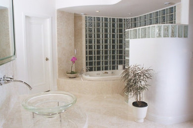 Immagine di una stanza da bagno design con vasca da incasso, doccia aperta, pareti beige, pavimento in pietra calcarea, lavabo a bacinella, pavimento beige e doccia aperta