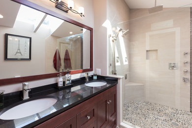 Mid-sized minimalist master beige tile and porcelain tile porcelain tile and beige floor bathroom photo in DC Metro with shaker cabinets, dark wood cabinets, a two-piece toilet, beige walls, an undermount sink, granite countertops and black countertops