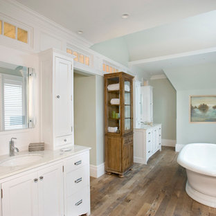 Example of a classic medium tone wood floor freestanding bathtub design in Boston with an undermount sink, shaker cabinets, white cabinets and green walls
