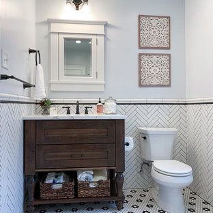 Kleines Modernes Duschbad mit Schrankfronten mit vertiefter Füllung, dunklen Holzschränken, Einbaubadewanne, Eckdusche, Wandtoilette mit Spülkasten, schwarz-weißen Fliesen, Metrofliesen, blauer Wandfarbe, Mosaik-Bodenfliesen, Unterbauwaschbecken, Marmor-Waschbecken/Waschtisch, buntem Boden, bunter Waschtischplatte und Falttür-Duschabtrennung in Philadelphia