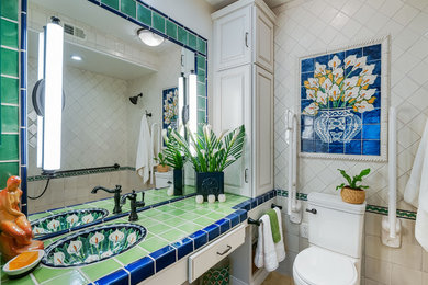 Example of a small tuscan master green tile and terra-cotta tile porcelain tile bathroom design in San Diego with raised-panel cabinets, white cabinets, a two-piece toilet, white walls, an undermount sink and tile countertops
