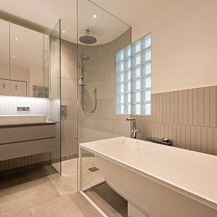 Design ideas for a medium sized contemporary ensuite bathroom in London with flat-panel cabinets, grey cabinets, white walls, a vessel sink, grey floors, an open shower, grey worktops, a freestanding bath, a corner shower and grey tiles.