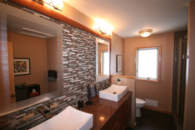 グランドラピッズにあるおしゃれな浴室 (ベッセル式洗面器、クオーツストーンの洗面台、マルチカラーのタイル) の写真