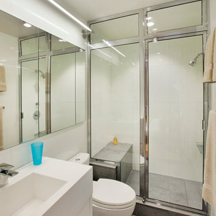 Small trendy 3/4 white tile and porcelain tile concrete floor and gray floor alcove shower photo in New York with flat-panel cabinets, white cabinets, a one-piece toilet, white walls, a console sink and a hinged shower door