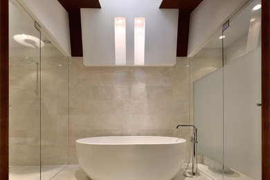 Bathroom - mid-sized contemporary master beige tile and travertine tile light wood floor and brown floor bathroom idea in Atlanta with flat-panel cabinets, dark wood cabinets, beige walls, an integrated sink, stainless steel countertops and a hinged shower door