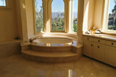 Mid-sized 1950s master marble floor and beige floor bathroom photo in Los Angeles with raised-panel cabinets, beige cabinets, a bidet, beige walls, an integrated sink, granite countertops, a hinged shower door and multicolored countertops