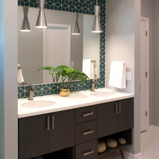 Mittelgroßes Retro Badezimmer En Suite mit flächenbündigen Schrankfronten, dunklen Holzschränken, grauer Wandfarbe, Unterbauwaschbecken, Mineralwerkstoff-Waschtisch, weißem Boden, weißer Waschtischplatte, Wandtoilette mit Spülkasten, grünen Fliesen, Keramikfliesen und Mosaik-Bodenfliesen in Chicago