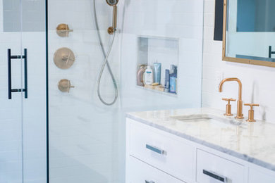 ニューヨークにある高級な広い北欧スタイルのおしゃれなマスターバスルーム (フラットパネル扉のキャビネット、白いキャビネット、コーナー設置型シャワー、白いタイル、サブウェイタイル、白い壁、セラミックタイルの床、アンダーカウンター洗面器、大理石の洗面台) の写真