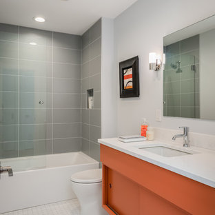 Example of a mid-sized 1950s kids' gray tile and ceramic tile ceramic tile and white floor bathroom design in Milwaukee with flat-panel cabinets, orange cabinets, gray walls, an undermount sink, quartz countertops and white countertops