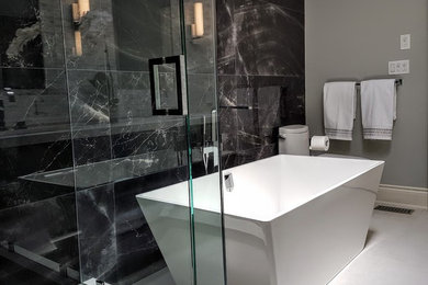 Example of a mid-sized minimalist master black and white tile and porcelain tile porcelain tile and gray floor bathroom design in Toronto with flat-panel cabinets, medium tone wood cabinets, a one-piece toilet, gray walls, an undermount sink, quartz countertops and a hinged shower door