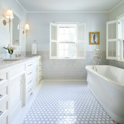 Freestanding bathtub - traditional gray tile gray floor freestanding bathtub idea in Minneapolis with recessed-panel cabinets, white cabinets, gray walls, an undermount sink and gray countertops