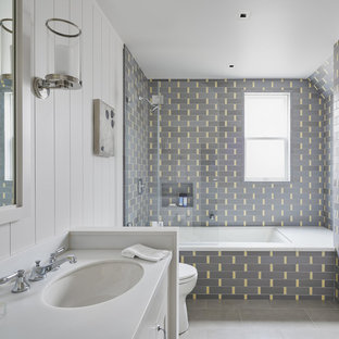 Tub/shower combo - mid-sized craftsman 3/4 gray tile, yellow tile and subway tile gray floor and concrete floor tub/shower combo idea in San Francisco with white cabinets, an undermount tub, white walls, an undermount sink, white countertops and solid surface countertops