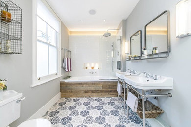 Mittelgroßes Modernes Badezimmer mit Einbaubadewanne, Duschbadewanne, Toilette mit Aufsatzspülkasten, weißen Fliesen, Porzellanfliesen, grauer Wandfarbe, Keramikboden, Waschtischkonsole, buntem Boden und Falttür-Duschabtrennung in London