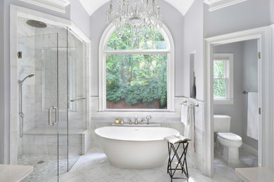 Transitional master marble tile and white tile marble floor and gray floor bathroom photo in Atlanta with a two-piece toilet, a hinged shower door and gray walls