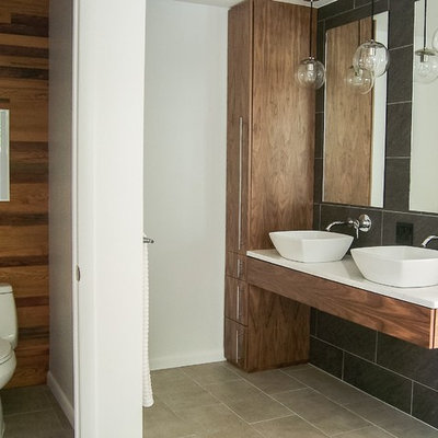 Mid-sized minimalist master gray tile and ceramic tile ceramic tile freestanding bathtub photo in Grand Rapids with quartzite countertops, flat-panel cabinets, medium tone wood cabinets, a one-piece toilet, a vessel sink and multicolored walls