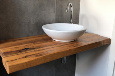Kleines Modernes Badezimmer mit grauen Fliesen, grauer Wandfarbe, Aufsatzwaschbecken, Waschtisch aus Holz, brauner Waschtischplatte, Einzelwaschbecken und schwebendem Waschtisch in Sonstige