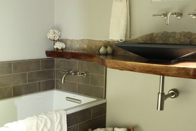 Inspiration for a small rustic bathroom in San Francisco with recessed-panel cabinets, grey cabinets, a built-in bath, a corner shower, a one-piece toilet, brown tiles, porcelain tiles, grey walls, porcelain flooring, a vessel sink and wooden worktops.