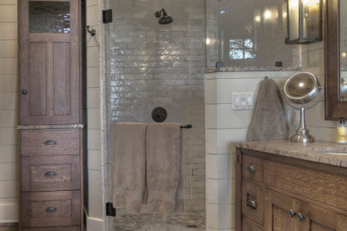 Imagen de cuarto de baño principal rural de tamaño medio con puertas de armario de madera oscura, paredes blancas, suelo de madera en tonos medios, suelo marrón y ducha con puerta con bisagras