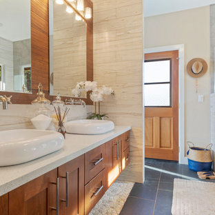 Foto di una stanza da bagno tropicale con ante in stile shaker, ante in legno scuro, piastrelle bianche, pareti beige, lavabo a bacinella, pavimento nero e top bianco