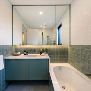 This is an example of a mid-sized contemporary kids bathroom in Sydney with shaker cabinets, green cabinets, an undermount tub, terrazzo floors, an undermount sink, engineered quartz benchtops, white benchtops, a single vanity, a floating vanity, green tile, a corner shower and white walls.