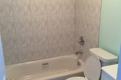 Diseño de cuarto de baño tradicional pequeño con armarios con paneles lisos, puertas de armario blancas, bañera empotrada, combinación de ducha y bañera, sanitario de dos piezas, baldosas y/o azulejos blancos, baldosas y/o azulejos de cerámica, suelo de baldosas de porcelana, aseo y ducha, encimera de acrílico, suelo blanco y ducha con cortina