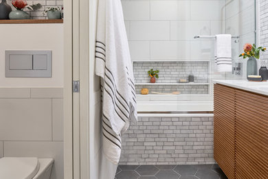 Inspiration for a white tile ceramic tile and gray floor bathroom remodel in San Francisco with an undermount tub, a wall-mount toilet, white walls, an undermount sink and quartz countertops