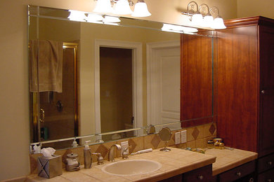 Example of a large bathroom design in Charlotte with a drop-in sink, dark wood cabinets and beige walls