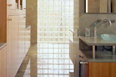 Imagen de cuarto de baño principal moderno grande con armarios con paneles lisos, puertas de armario de madera clara, paredes grises, suelo de cemento, lavabo sobreencimera, encimera de cemento y suelo gris