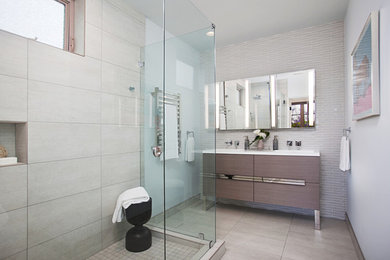 Corner shower - mid-sized modern master white tile and glass tile ceramic tile and gray floor corner shower idea in San Diego with flat-panel cabinets, gray cabinets, a bidet, blue walls, an integrated sink, quartzite countertops and a hinged shower door