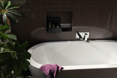 Mittelgroßes Modernes Badezimmer En Suite mit freistehender Badewanne, braunen Fliesen, Porzellanfliesen, brauner Wandfarbe, Porzellan-Bodenfliesen und braunem Boden in Melbourne