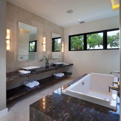Example of a minimalist limestone tile bathroom design in Orlando with a vessel sink