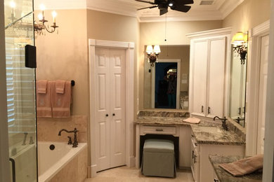 Bild på ett mellanstort vintage en-suite badrum, med luckor med infälld panel, vita skåp, granitbänkskiva, ett platsbyggt badkar, en hörndusch, beige kakel, stenkakel, beige väggar och travertin golv