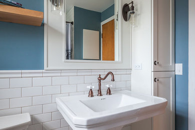 Cette photo montre une salle de bain romantique de taille moyenne pour enfant avec un placard à porte shaker, des portes de placard blanches, une baignoire en alcôve, un combiné douche/baignoire, WC séparés, un carrelage blanc, un carrelage métro, un mur bleu, un sol en carrelage de céramique, un lavabo de ferme, un sol blanc et une cabine de douche avec un rideau.