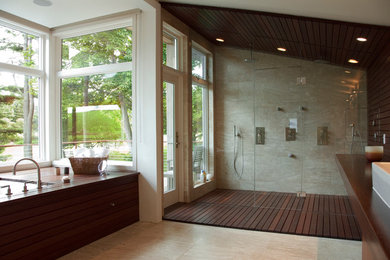 ブリッジポートにある広いモダンスタイルのおしゃれなマスターバスルーム (濃色木目調キャビネット、アルコーブ型浴槽、アルコーブ型シャワー、ベージュのタイル、ベージュの壁、セラミックタイルの床、ベッセル式洗面器) の写真