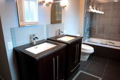Example of a mid-sized minimalist master gray tile and porcelain tile porcelain tile bathroom design in Portland with an undermount sink, flat-panel cabinets, brown cabinets, quartz countertops, a two-piece toilet and blue walls