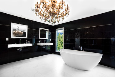 Example of a large minimalist master black tile and glass sheet concrete floor bathroom design in New York with an integrated sink, open cabinets, white cabinets, quartz countertops, a one-piece toilet and black walls