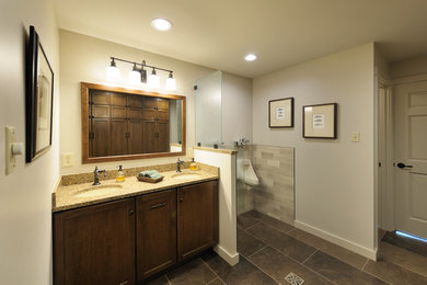 Mid-sized elegant master beige tile and porcelain tile porcelain tile and brown floor bathroom photo in Other with recessed-panel cabinets, medium tone wood cabinets, white walls, an undermount sink, granite countertops and an urinal