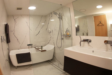 シドニーにあるモダンスタイルのおしゃれな浴室 (フラットパネル扉のキャビネット、黒いキャビネット、アルコーブ型シャワー、白いタイル、セラミックタイル、白い壁、セラミックタイルの床、横長型シンク、クオーツストーンの洗面台、開き戸のシャワー、白い洗面カウンター) の写真
