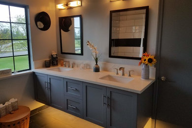 Ejemplo de cuarto de baño minimalista con puertas de armario grises, sanitario de dos piezas, paredes grises, lavabo encastrado, encimera de cuarcita, suelo negro y encimeras blancas