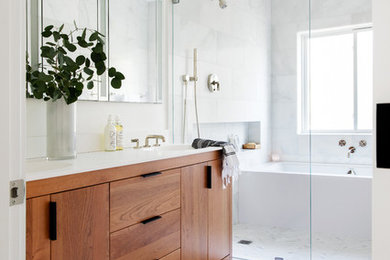 Inspiration for a mid-sized modern master white tile and stone tile marble floor and white floor bathroom remodel in San Francisco with furniture-like cabinets, medium tone wood cabinets, an undermount tub, a one-piece toilet, white walls, an integrated sink, quartz countertops and white countertops
