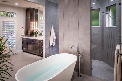 Modelo de cuarto de baño principal minimalista grande con armarios estilo shaker, puertas de armario de madera en tonos medios, bañera exenta, ducha abierta y paredes grises