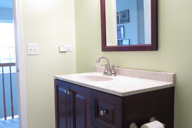 Exemple d'une salle de bain moderne en bois foncé de taille moyenne pour enfant avec un plan de toilette en surface solide, un carrelage beige et un mur vert.