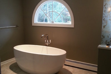 Cette image montre une grande salle de bain principale design avec une baignoire indépendante et un mur marron.