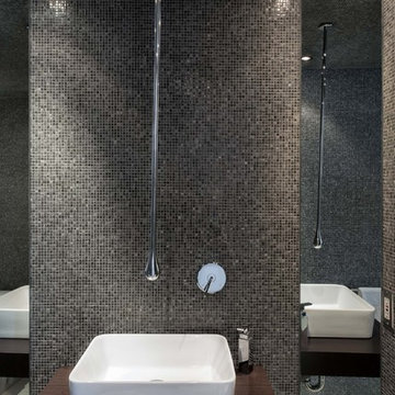 Modern bathroom with wood counter and glass mosaic walls